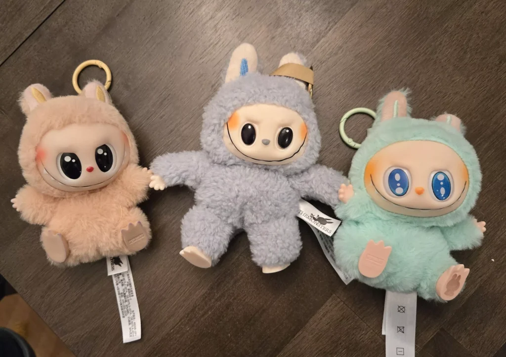 A close-up of a Lafufu plush toy, a knockoff version of Labubu with mismatched eyes